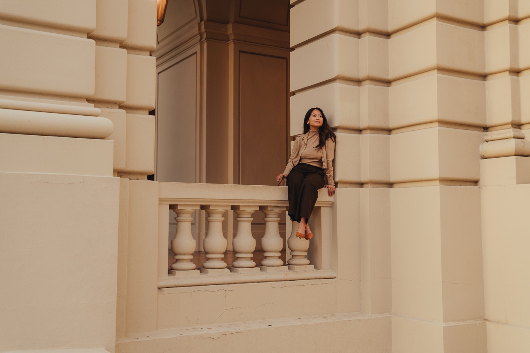 Denise Chicano sitting on a stone balcony